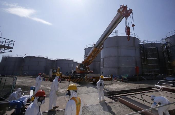 Workers wearing protective suits and masks are seen near tanks of radiation contaminated water at Tokyo Electric Power Company's (TEPCO) tsunami-crippled Fukushima Daiichi nuclear power plant in Fukushima prefecture March 6, 2013, ahead of the second-year of anniversary of the the March 11, 2011 tsunami and earthquake. REUTERS/Issei Kato (JAPAN - Tags: DISASTER ANNIVERSARY) Published: Bře. 6, 2013, 11:26 dop.