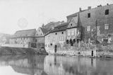 Pohled na zadní části domů čp. 1225 a 1226 na Novém Městě s náspem v místech někdejších Dolních Lodeckých mlýnů. V pozadí Feundův mlýn (dům čp. 1224). Cca před rokem 1910