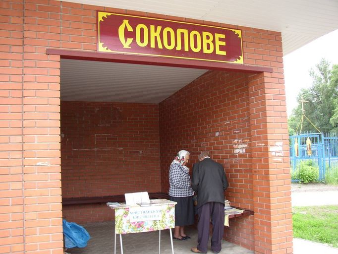 Na autobusové zastávce je zároveň stánek s křesťanskou literaturou... Paní válku nepamatuje, ale vpzomněla si, jak tam později českoslovenští filmaři natáčeli film Sokolovo (Byl to režisér Otakar Vávra, který ve svých pamětech vzpomíná, že mu sovětské úřady dlouho odmítaly povolit natáčení ve skutečném Sokolovu).