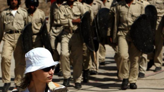 Speciální policejní jednotka míjí turistku na ulici v Dahábu.