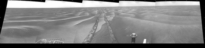 Opportunity's View on Sol 1798 NASA's Mars Exploration Rover Opportunity used its navigation camera to take the images combined into this 180-degree view of the rover's surroundings during the 1,798th Martian day, or sol, of Opportunity's surface mission (Feb. 13, 2009). North is at the center, west on the left, east on the right. The rover had driven 111 meters (364 feet) southward on the preceding sol. Tracks from that drive recede northward in this view. For scale, the distance between the parallel wheel tracks is about 1 meter (about 40 inches). The terrain in this portion of Mars' Meridiani Planum region includes dark-toned sand ripples and lighter-toned bedrock. This view is presented as a cylindrical projection with geometric seam correction. Image Credit: NASA/JPL-Caltech