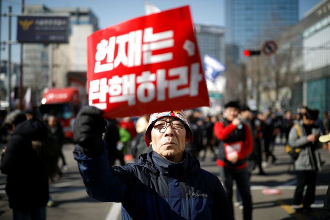 Lidé před soudní budovou reagují na odvolání jihokorejské prezidentky Pak Kun-hje z funkce.