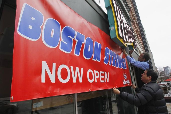 Wendy's District Manager Pico Kouhail (L) and coworker Andrew Cole hang an open sign on their restaurant on Boylston Street after the street reopened to the public for the first time since the Boston Marathon bombings in Boston, Massachusetts April 24, 2013. REUTERS/Jessica Rinaldi (UNITED STATES - Tags: CRIME LAW CIVIL UNREST SOCIETY BUSINESS) Published: Dub. 24, 2013, 3:33 odp.