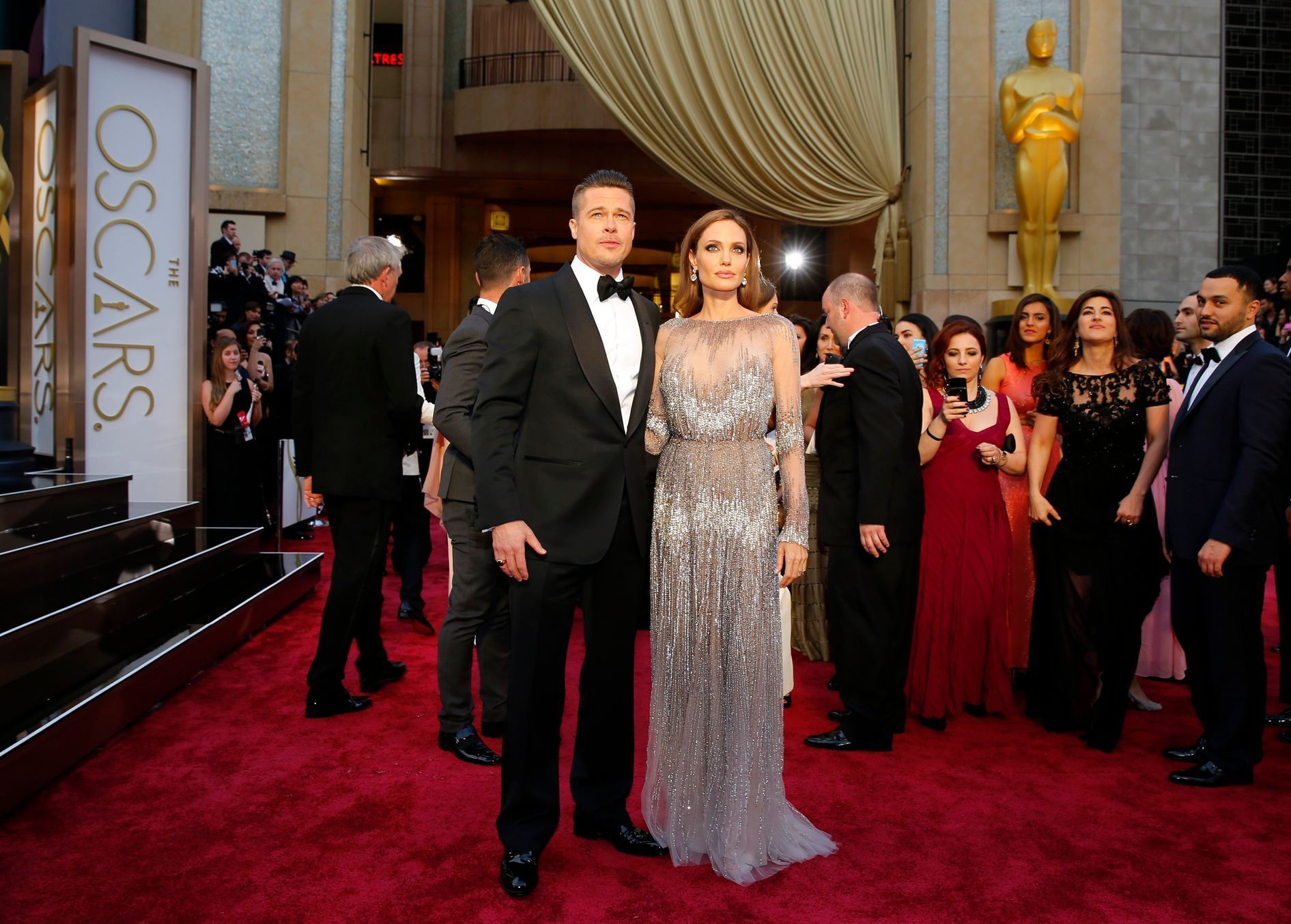 Actors Brad Pitt and Angelina Jolie, wearing a silver Elie Saab gown, arrive at the 86th Academy Awards in Hollywood