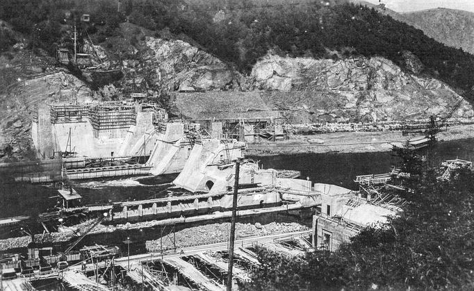 Historická fotografie zachycující výstavbu vodní nádrže Štěchovice, která probíhala mezi lety 1937 a 1944, navzdory válečným komplikacím.