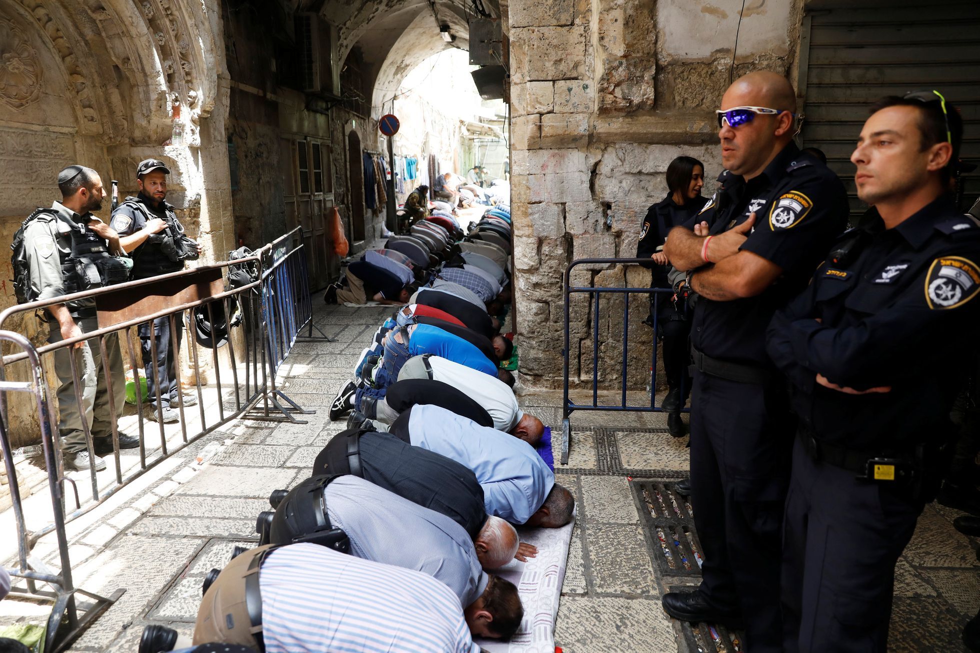Palestinci se modlí pod dohledem izraelských bezpečnostních složek na Chrámové hoře.
