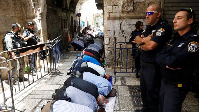 Palestinci se modlí pod dohledem izraelských bezpečnostních složek na Chrámové hoře.