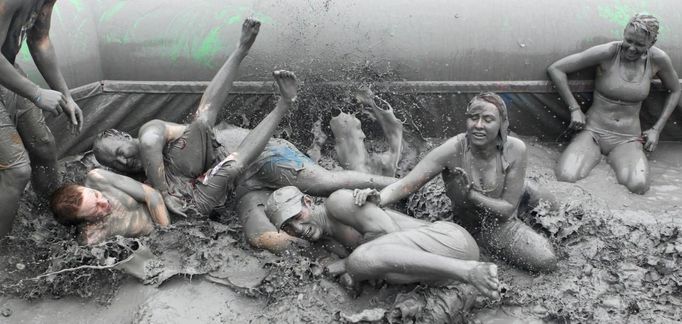 Tourists play in mud during the opening day of the Boryeong Mud Festival at Daecheon beach in Boryeong, about 190 km (118 miles) southwest of Seoul, July 14, 2012. About 2 to 3 million domestic and international tourists visit the beach during the annual festival, according to the festival organisation. REUTERS/Lee Jae-Won (SOUTH KOREA - Tags: SOCIETY TRAVEL) Published: Čec. 14, 2012, 1:31 odp.