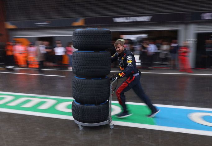Mechanik Red Bullu spěchá s pneumatikami na mokrou vozovku na start sprintu F1 ve Spa-Francorchamps.