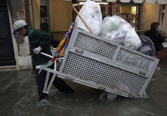 A worker pulls a garbage cart during a period of seasonal high water in Venice October 27, 2012. The water level in the canal city rose to 127 cm (50 inches) above the normal level, according to the monitoring institute. REUTERS/Manuel Silvestri (ITALY - Tags: ENVIRONMENT SOCIETY TRAVEL) Published: Říj. 27, 2012, 12:19 odp.