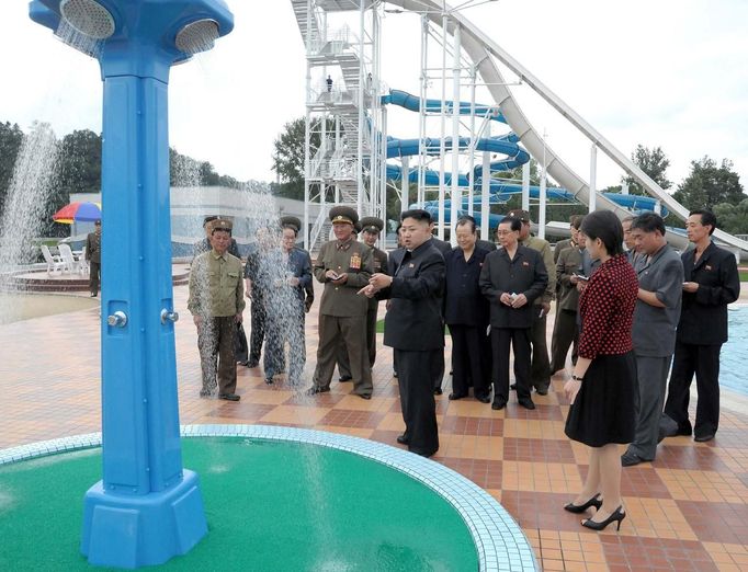 North Korean leader Kim Jong-Un (C) and an unidentified woman (red) visit the Rungna People's Pleasure Ground, which is nearing completion, in this undated picture released by the North's KCNA in Pyongyang on July 25, 2012. REUTERS/KCNA (NORTH KOREA - Tags: POLITICS) THIS IMAGE HAS BEEN SUPPLIED BY A THIRD PARTY. IT IS DISTRIBUTED, EXACTLY AS RECEIVED BY REUTERS, AS A SERVICE TO CLIENTS. NO THIRD PARTY SALES. NOT FOR USE BY REUTERS THIRD PARTY DISTRIBUTORS. QUALITY FROM SOURCE Published: Čec. 25, 2012, 10:48 dop.