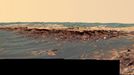 'Payson' Panorama in False Color 3/7/06 The panoramic camera aboard NASA's Mars Exploration Rover Opportunity acquired this panorama of the "Payson" outcrop on the western edge of "Erebus" Crater during Opportunity's sol 744 (Feb. 26, 2006). From this vicinity at the northern end of the outcrop, layered rocks are observed in the crater wall, which is about 1 meters (3.3 feet) thick. The view also shows rocks disrupted by the crater-forming impact event and subjected to erosion over time. To the left of the outcrop, a flat, thin layer of spherule-rich soils overlies more outcrop materials. The rover is currently traveling down this "road" and observing the approximately 25-meter (82-foot) length of the outcrop prior to departing Erebus crater. The panorama camera took 28 separate exposures of this scene, using four different filters. The resulting panorama covers about 90 degrees of terrain around the rover. This false-color rendering was made using the camera's 753-nanometer, 535-nanometer and 423-nanometer filters. Using false color enhances the subtle color differences between layers of rocks and soils in the scene so that scientists can better analyze them. Image-to-image seams have been eliminated from the sky portion of the mosaic to better simulate the vista a person standing on Mars would see. Image Credit: NASA/JPL-Caltech/USGS/Cornell