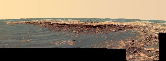 'Payson' Panorama in False Color 3/7/06 The panoramic camera aboard NASA's Mars Exploration Rover Opportunity acquired this panorama of the "Payson" outcrop on the western edge of "Erebus" Crater during Opportunity's sol 744 (Feb. 26, 2006). From this vicinity at the northern end of the outcrop, layered rocks are observed in the crater wall, which is about 1 meters (3.3 feet) thick. The view also shows rocks disrupted by the crater-forming impact event and subjected to erosion over time. To the left of the outcrop, a flat, thin layer of spherule-rich soils overlies more outcrop materials. The rover is currently traveling down this "road" and observing the approximately 25-meter (82-foot) length of the outcrop prior to departing Erebus crater. The panorama camera took 28 separate exposures of this scene, using four different filters. The resulting panorama covers about 90 degrees of terrain around the rover. This false-color rendering was made using the camera's 753-nanometer, 535-nanometer and 423-nanometer filters. Using false color enhances the subtle color differences between layers of rocks and soils in the scene so that scientists can better analyze them. Image-to-image seams have been eliminated from the sky portion of the mosaic to better simulate the vista a person standing on Mars would see. Image Credit: NASA/JPL-Caltech/USGS/Cornell