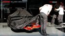 Mechanici halí v boxech ve Spa monopost McLaren pod plachtu. Tým kvůli špionážní kauze přišel o všechny letošní body v Poháru konstruktérů.