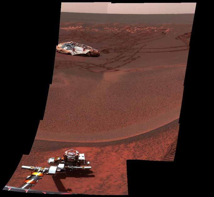 Lion King Surveys Homeland 4/1/04 This image from the Mars Exploration Rover Opportunity's panoramic camera shows one octant of a larger panoramic image which has not yet been fully processed. The full panorama, dubbed "Lion King" was obtained on sols 58 and 60 of the mission as the rover was perched at the lip of Eagle Crater, majestically looking down into its former home. It is the largest panorama yet obtained by either rover. The octant, which faces directly into the crater, shows features as small as a few millimeters across in the field near the rover arm, to features a few meters across or larger on the horizon. The full panoramic image was taken in eight segments using six filters per segment, for a total of 558 images and more than 75 megabytes of data. This enhanced color composite was assembled from the infrared (750 nanometer), green (530 nanometer), and violet (430 nanometer) filters. Additional lower elevation tiers were added relative to other panoramas to ensure that the entire crater was covered in the mosaic.. Image Credit: NASA/JPL/Cornell