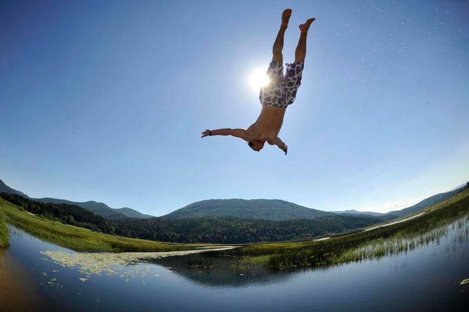 Chlapec skáče do Cerknického jezera. Jde o velmi unikátní přírodní jev. Jezero se rozkládá v blízkosti města Cerknica a není trvalé, jelikož vysychá. Celková plocha jezera dosahuje až 40 km2. Nejvíce vody je v jezeře na jaře během tání sněhu. Do podzimu jezero postupně vysychá a pak se opět naplní vodou.