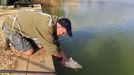 Kevin Hewitt of England releases an underweight carp during the 14th Carpfishing World Championship in Corbu village, 310 km (192 miles) east of Bucharest, September 29, 2012. REUTERS/Radu Sigheti (ROMANIA - Tags: SOCIETY) Published: Zář. 29, 2012, 4:36 odp.