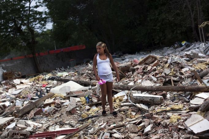 Erica Escudero recovers her little sister's shoes from the rubble of her grandparents' home at the Spanish gypsy settlement of Puerta de Hierro, in the outskirts of Madrid July 25, 2012. Fifty-four families have been living in Puerta de Hierro, on the banks of the Manzanares river for over 50 years. Since the summer of 2010, the community has been subject to evictions on the grounds that the dwellings are illegal. Families whose houses have been demolished, move in with relatives whose houses still remain while the debris keeps piling up around them as more demolitions take place. Picture taken July 25, 2012. REUTERS/Susana Vera (SPAIN - Tags: SOCIETY) ATTENTION EDITORS - PICTURE 23 OF 31 FOR PACKAGE 'GYPSY SITE DEMOLISHED' SEARCH 'GYPSY SITE' FOR ALL IMAGES Published: Lis. 5, 2012, 4:12 odp.