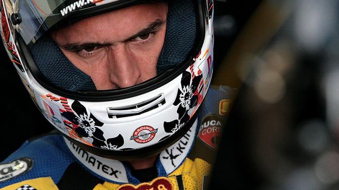 Jakub Smrž mlčky hledí na svůj motocykl Ducati 1098 RS08 v zázemí týmu Guandalini Racing by Grifo's.
