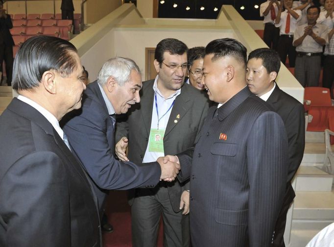 th Korean leader Kim shakes hands with unidentified officials of the International Weightlifting Federation and the Asian Weightlifting Federation during the 2013 Asian C