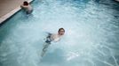 Davidson Aero Smith (R), 7, swims in the pool at Village Trailer Park in Santa Monica, California, July 13, 2012. Developer Marc Luzzatto wants to relocate residents from the trailer park to make way for nearly 500 residences, office space, stores, cafes and yoga studios, close to where a light rail line is being built to connect downtown Los Angeles to the ocean. Village Trailer Park was built in 1951, and 90 percent of its residents are elderly, disabled or both, according to the Legal Aid Society. Many have lived there for decades in old trailers which they bought. The property is valued at as much as $30 million, according the LA Times. REUTERS/Lucy Nicholson (UNITED STATES - Tags: SOCIETY REAL ESTATE BUSINESS POLITICS) Published: Čec. 14, 2012, 7:52 dop.