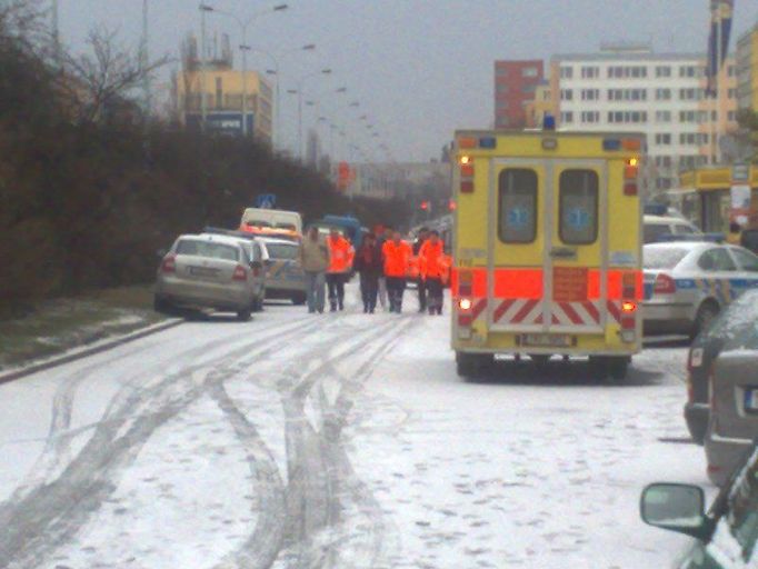 Záchranáři doprovázejí druhou propuštěnou rukojmí k sanitce