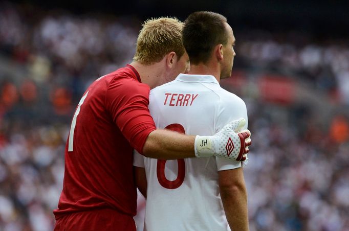 Joe Hart si staví Johna Terryho kvůli pokutovému kopu soupeře během přátelského fotbalového utkání Anglie - Belgie.