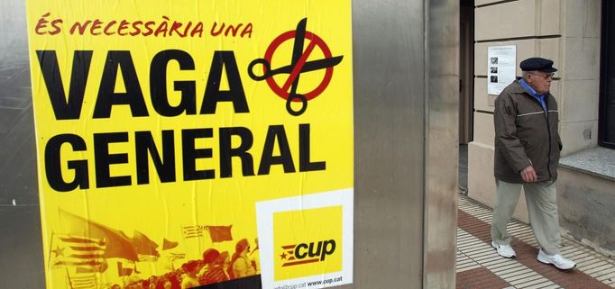 A man walks past a poster calling for a general strike in El Masnou, near Barcelona November 13, 2012. Spain's two largest labour unions have called for a general strike on November 14, the second against the conservative government since they took power in December and coinciding with industrial action in Portugal on the same day. REUTERS/Albert Gea (SPAIN - Tags: CIVIL UNREST POLITICS BUSINESS) Published: Lis. 13, 2012, 5:18 odp.