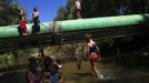 Children play at the river that borders the Spanish gypsy settlement of Puerta de Hierro outside Madrid August 12, 2012. Fifty-four families have been living in Puerta de Hierro, on the banks of the Manzanares river for over 50 years. Since the summer of 2010, the community has been subject to evictions on the grounds that the dwellings are illegal. Families whose houses have been demolished, move in with relatives whose houses still remain while the debris keeps piling up around them as more demolitions take place. Picture taken August 12, 2012. REUTERS/Susana Vera (SPAIN - Tags: SOCIETY) ATTENTION EDITORS - PICTURE 20 OF 31 FOR PACKAGE 'GYPSY SITE DEMOLISHED' SEARCH 'GYPSY SITE' FOR ALL IMAGES Published: Lis. 5, 2012, 4:12 odp.