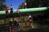 Ještě v srpnu 2012 panoval v osadě relativní klid. Děti se v parnu koupaly v řece.