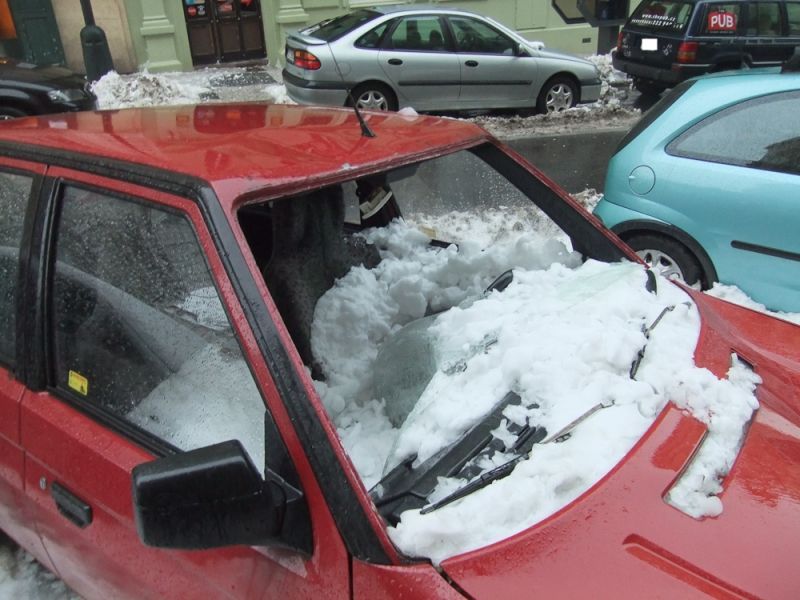 Auta poničená sněhem v pražské Hálkově ulici.