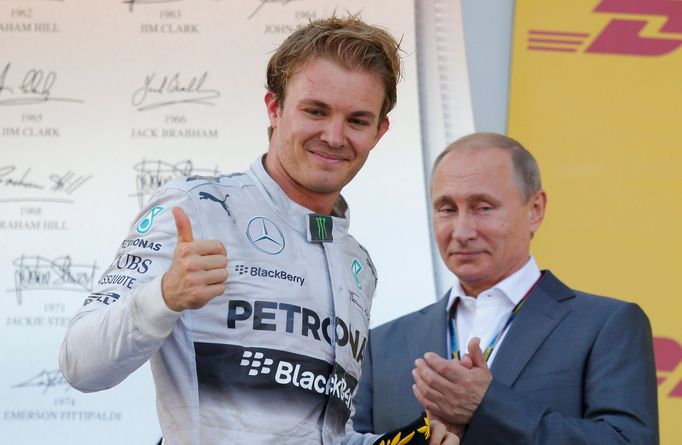 Russian President Vladimir Putin applaudes Mercedes Formula One driver Nico Rosberg of Germany after the first Russian Grand Prix in Sochi October 12, 2014. REUTERS/Laszl