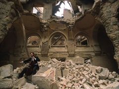 Čelista Vedran Smailovič hraje ve zničené Národní knihovně v Sarajevu. Snímek pochází z roku 1992, dnes se budova opravuje
