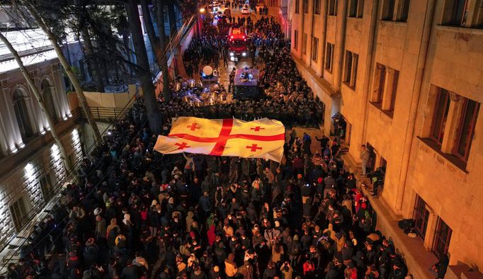 Strážci zákona zadržují muže během shromáždění proti zákonu o "zahraničních agentech" v gruzínském Tbilisi.