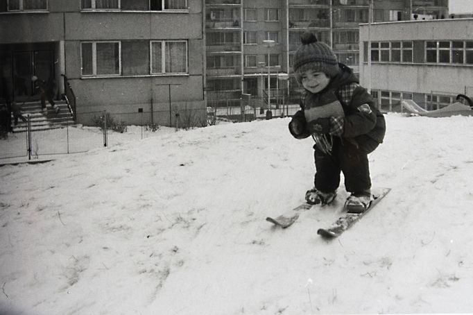 Malá lyžařka, cca 3,5 roku, na sídlišti Jižní Město v Praze, rok 1985. K dětskému nadšení postačil navážkový kopec zapadaný sněhem.