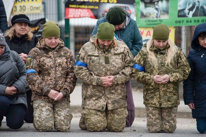 Fotografie žen sloužících během ruské invaze na Ukrajinu v ukrajinské armádě. Záběr piety za padlé vojáky. Datum pořízení snímku: 16. 3. 2022.