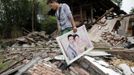 A man recovers his wedding photo from the wreckage of his house after Saturday's earthquake in Longmen township of Lushan county, Sichuan province, April 21, 2013. Rescuers struggled to reach a remote, rural corner of southwestern China on Sunday as the toll of the dead and missing from the country's worst earthquake in three years climbed to 208 with almost 1,000 serious injuries. The 6.6 magnitude quake struck in Lushan county, near the city of Ya'an in the southwestern province of Sichuan, close to where a devastating 7.9 quake hit in May 2008, killing 70,000. Picture taken April 21, 2013. REUTERS/Rooney Chen (CHINA - Tags: DISASTER SOCIETY) Published: Dub. 22, 2013, 3:09 dop.