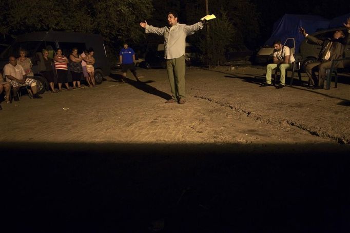 An evangelical pastor preaches at the Spanish gypsy settlement of Puerta de Hierro outside Madrid August 15, 2012. Fifty-four families have been living in Puerta de Hierro, on the banks of the Manzanares river for over 50 years. Since the summer of 2010, the community has been subject to evictions on the grounds that the dwellings are illegal. Families whose houses have been demolished, move in with relatives whose houses still remain while the debris keeps piling up around them as more demolitions take place. Picture taken August 15, 2012. REUTERS/Susana Vera (SPAIN - Tags: SOCIETY) ATTENTION EDITORS - PICTURE 25 OF 31 FOR PACKAGE 'GYPSY SITE DEMOLISHED' SEARCH 'GYPSY SITE' FOR ALL IMAGES Published: Lis. 5, 2012, 4:12 odp.