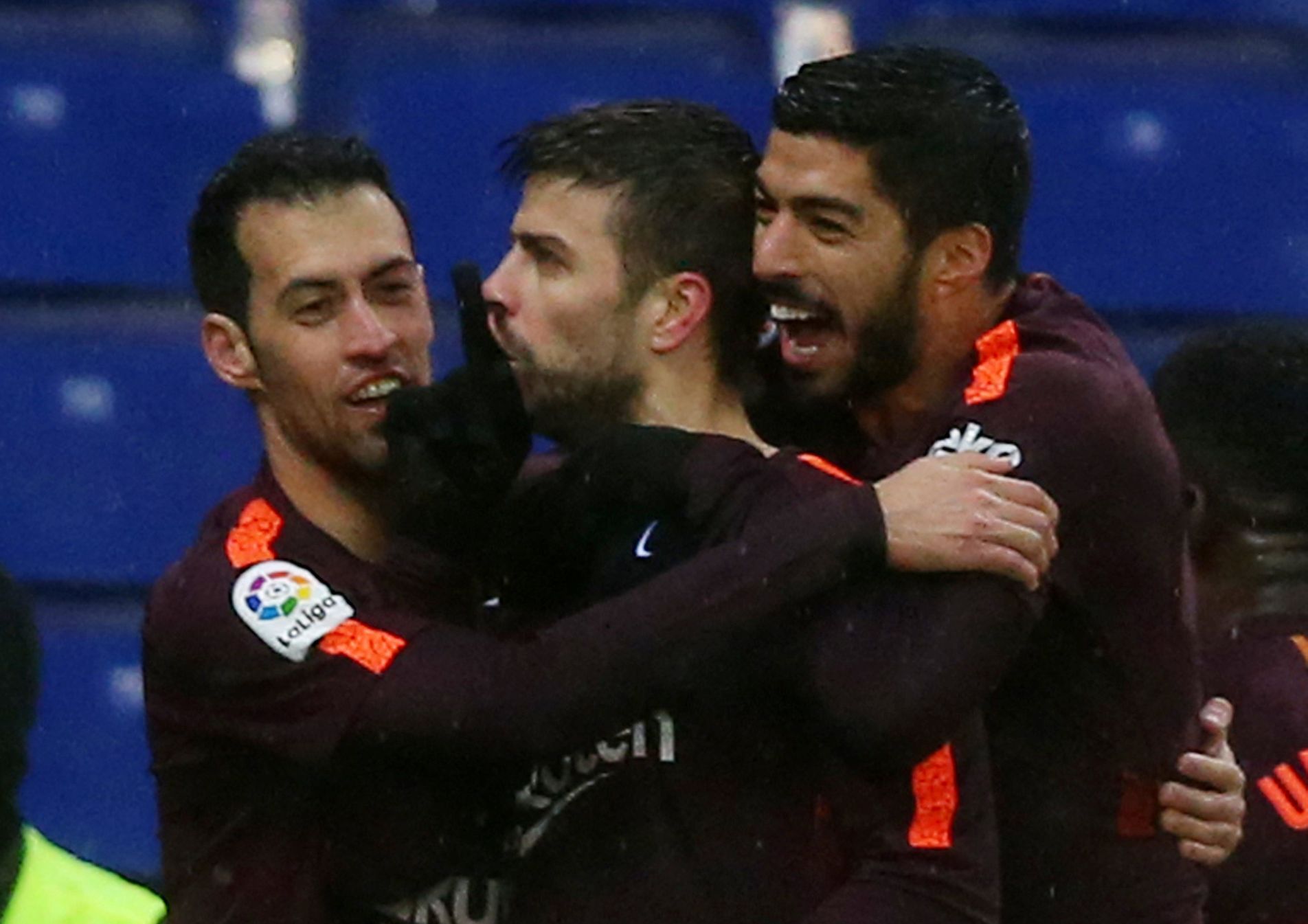 Gerard Piqué (uprostřed) slaví se spoluhráči z FC Barcelona Sergiem Busquetsem a Luisem Suárezem gól, kterým v utkání s Espaňolem vyrovnal na konečných 1:1