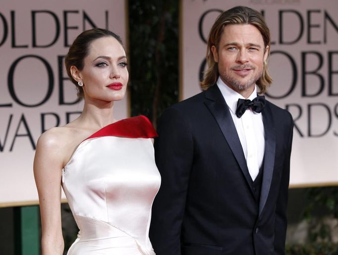 Actors Angelina Jolie and Brad Pitt pose for photographers as they arrive at the 69th annual Golden Globe Awards in Beverly Hills, California in this January 15, 2012 file photo. Oscar-winning actress Jolie said on May 14, 2013 that she had undergone a preventive double mastectomy after finding out she had a gene mutation that leads to a sharply higher risk of both breast and ovarian cancer. Jolie, writing in the New York Times, said her mother's death from cancer at 56 and the discovery that she carried the BRCA1 gene mutation led to her decision out of fears she might not be around for her six children. REUTERS/Mario Anzuoni/Files (UNITED STATES - Tags: ENTERTAINMENT HEALTH) Published: Kvě. 14, 2013, 8 dop.