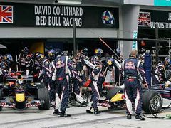 Mechanici týmu Red Bull tlačí monopost Davida Coultharda (vlevo) do boxů, zatímco Christian Klien tankuje a mění pneumatiky