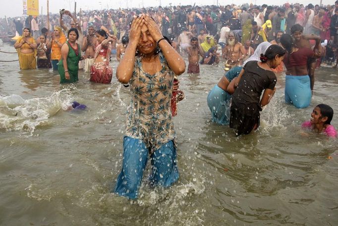 Hindu devotees take a dip during the first "Shahi Snan" (grand bath) at the ongoing "Kumbh Mela", or Pitcher Festival, in the northern Indian city of Allahabad January 14, 2013. Upwards of a million elated Hindu holy men and pilgrims took a bracing plunge in India's sacred Ganges river to wash away lifetimes of sins on Monday, in a raucous start to an ever-growing religious gathering that is already the world's largest. REUTERS/Jitendra Prakash (INDIA - Tags: RELIGION SOCIETY) Published: Led. 14, 2013, 12:03 odp.