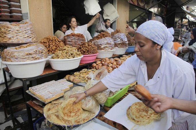 A vendor sells traditional cakes of fried honey and flour pastries to customers ahead of Ramadan in the medina of the Moroccan city of Rabat July 8, 2013. Ramadan, the Muslim fasting month, begins in Morocco on July 10 as each state determines when the fast should begin. Muslims around the world abstain from eating, drinking and sexual relations from sunrise to sunset during Ramadan, the holiest month in the Islamic calendar. REUTERS/Stringer (MOROCCO - Tags: FOOD SOCIETY RELIGION) Published: Čec. 8, 2013, 11:04 odp.