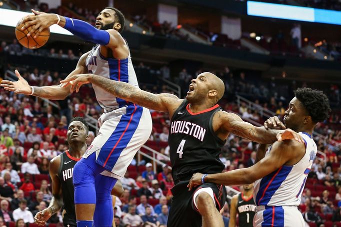 Andre Drummond  z Detroitu (vlevo) bojuje o míč s hvězdou Houstonu PJ Tuckerem.