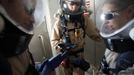 Matt Cross (L), rover engineer, Hans van Ot Woud (C), mapping researcher and health and safety officer, and Melissa Battler, geologist and commander of Crew 125 EuroMoonMars B mission of the Mars Desert Research Station (MDRS), wait in an airlock in their simulated spacesuits before venturing out to collect geologic samples in the Utah desert March 2, 2013. The MDRS aims to investigate the feasibility of a human exploration of Mars and uses the Utah desert's Mars-like terrain to simulate working conditions on the red planet. Scientists, students and enthusiasts work together developing field tactics and studying the terrain. All outdoor exploration is done wearing simulated spacesuits and carrying air supply packs and crews live together in a small communication base with limited amounts of electricity, food, oxygen and water. Everything needed to survive must be produced, fixed and replaced on site. Picture taken March 2, 2013. REUTERS/Jim Urquhart (UNITED STATES - Tags: SCIENCE TECHNOLOGY SOCIETY ENVIRONMENT) ATTENTION EDITORS: PICTURE 11 OF 31 FOR PACKAGE 'MARS IN THE DESERT' SEARCH 'JIM MARS' FOR ALL IMAGES Published: Bře. 11, 2013, 2:04 odp.