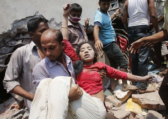 People rescue a garment worker who was trapped under the rubble of the collapsed Rana Plaza building in Savar, 30 km (19 miles) outside Dhaka April 24, 2013. The eight-st