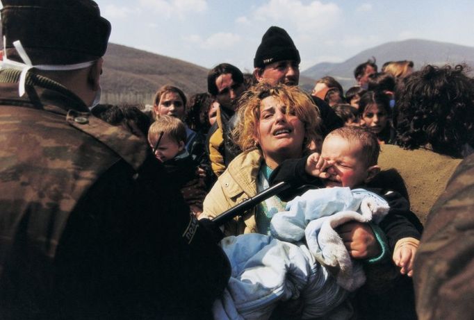 Fotografie roku 1999. Kosovská matka zastavená na hranicí Makedonie, Blace, březen - duben 1999. Tisíce kosovských Albánců prchaly během válečného konfliktu v bývalé Jugoslávii před střelbou ozbrojených oddílu do sousední Makedonie. Makedonští vojáci je ale nepoušteli dál. Drželi je v hraničním pásmu a ani zástupce humanitárních organizací po řadu dní nepouštěli ani k umírajícím.