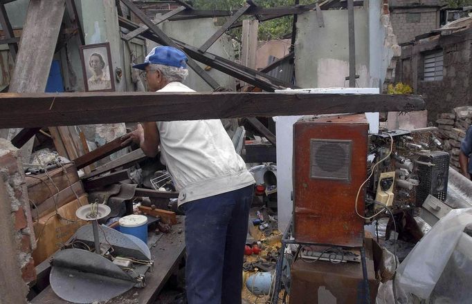 A man moves his belongings which were damaged by Hurricane Sandy in Santiago de Cuba October 25, 2012. Hurricane Sandy grew into a major potential threat to the east coast of the United States on Thursday after hammering Cuba's second-largest city and taking aim at the Bahamas, U.S. forecasters said. Strengthening rapidly after tearing into Jamaica and crossing the warm Caribbean Sea, Sandy hit southeastern Cuba early on Thursday with 105-mph winds that cut power and blew over trees across the city of Santiago de Cuba. Reports from the city of 500,000 people, about 470 miles (750 km) southeast of Havana spoke of significant damage, with many homes damaged or destroyed. According to one Cuban radio report, at least one person was killed, bringing the death toll to at least three after fatalities in Jamaica and Haiti. REUTERS/Miguel Rubiera/Cuban Government National Information Agency - AIN/Handout (CUBA - Tags: ENVIRONMENT DISASTER) FOR EDITORIAL USE ONLY. NOT FOR SALE FOR MARKETING OR ADVERTISING CAMPAIGNS. THIS IMAGE HAS BEEN SUPPLIED BY A THIRD PARTY. IT IS DISTRIBUTED, EXACTLY AS RECEIVED BY REUTERS, AS A SERVICE TO CLIENTS Published: Říj. 25, 2012, 5:54 odp.