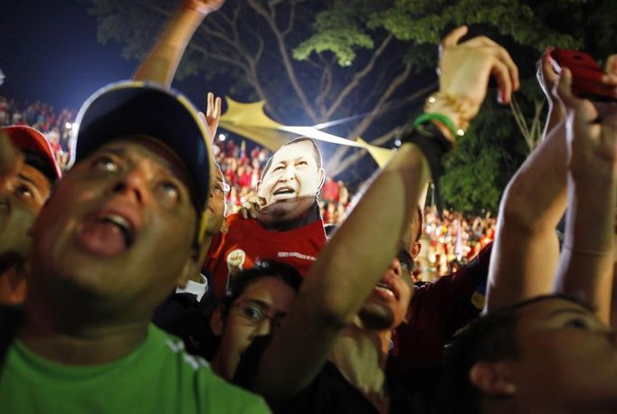 Supporters of Venezuelan President Hugo Chavez cheer as he appears on a balcony of Miraflores Palace in Caracas October 7, 2012. Venezuela's socialist President Chavez won re-election in Sunday's vote with 54 percent of the ballot to beat opposition challenger Henrique Capriles. REUTERS/Tomas Bravo (VENEZUELA - Tags: POLITICS ELECTIONS) Published: Říj. 8, 2012, 5:52 dop.