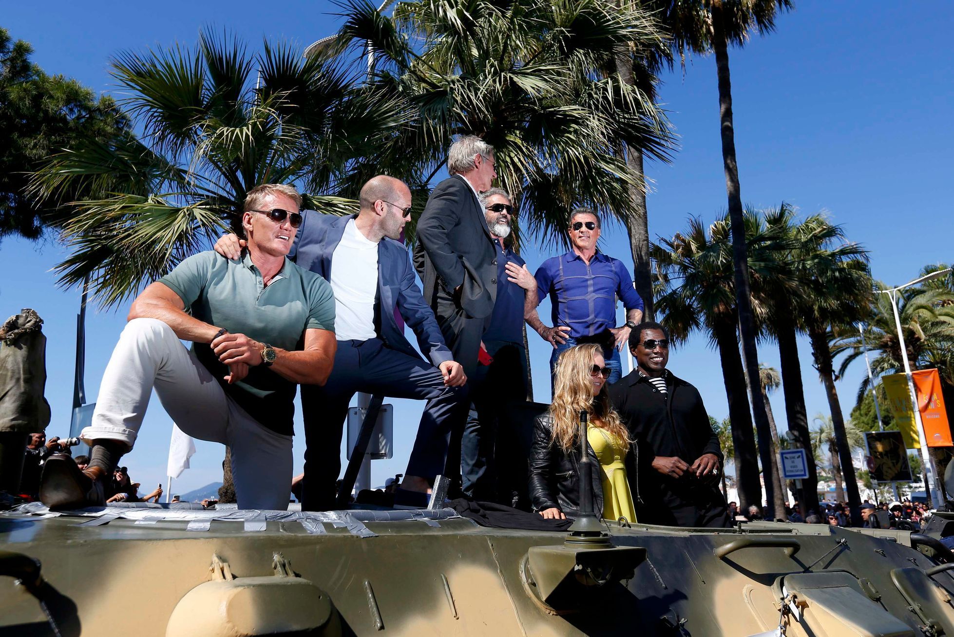 Cast members Lundgren, Statham, Ford, Gibson, Rousey, Stallone and Snipes pose on a tank as they arrive on the Croisette to promote the film &quot;The Expendables 3&quot; during the 67th Cannes Film F